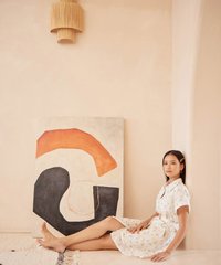 model wearing hvv atelier lucia floral embroidered shirtdress in white sitting