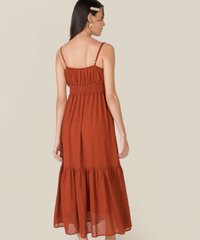 back view of model in belize swiss dot maxi dress in rust colour