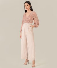 model wearing rose pink floral smocked blouse and pale nude wide leg pants