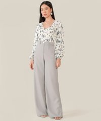 model wearing white floral smocked blouse and pale grey wide leg pants