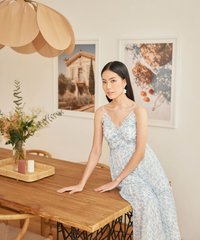 model wearing hvv atelier allons floral ruffle maxi dress in blue at home