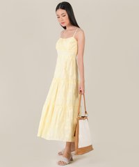 model wearing floral embroidered maxi dress in yellow carrying bag