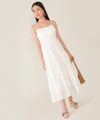 model wearing floral embroidered maxi dress in white carrying bag