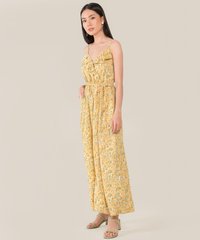 model standing in resa abstract floral ruffle jumpsuit in daffodil colour