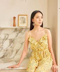 model sitting in resa abstract floral ruffle jumpsuit in daffodil colour