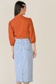 back view of elm striped texted blouse in burnt orange and denim midi skirt