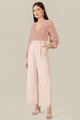 model wearing rose pink floral smocked blouse and pale nude wide leg pants