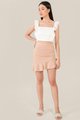 model wearing pinnacle ruched ruffle skirt in nude pink and white eyelet top