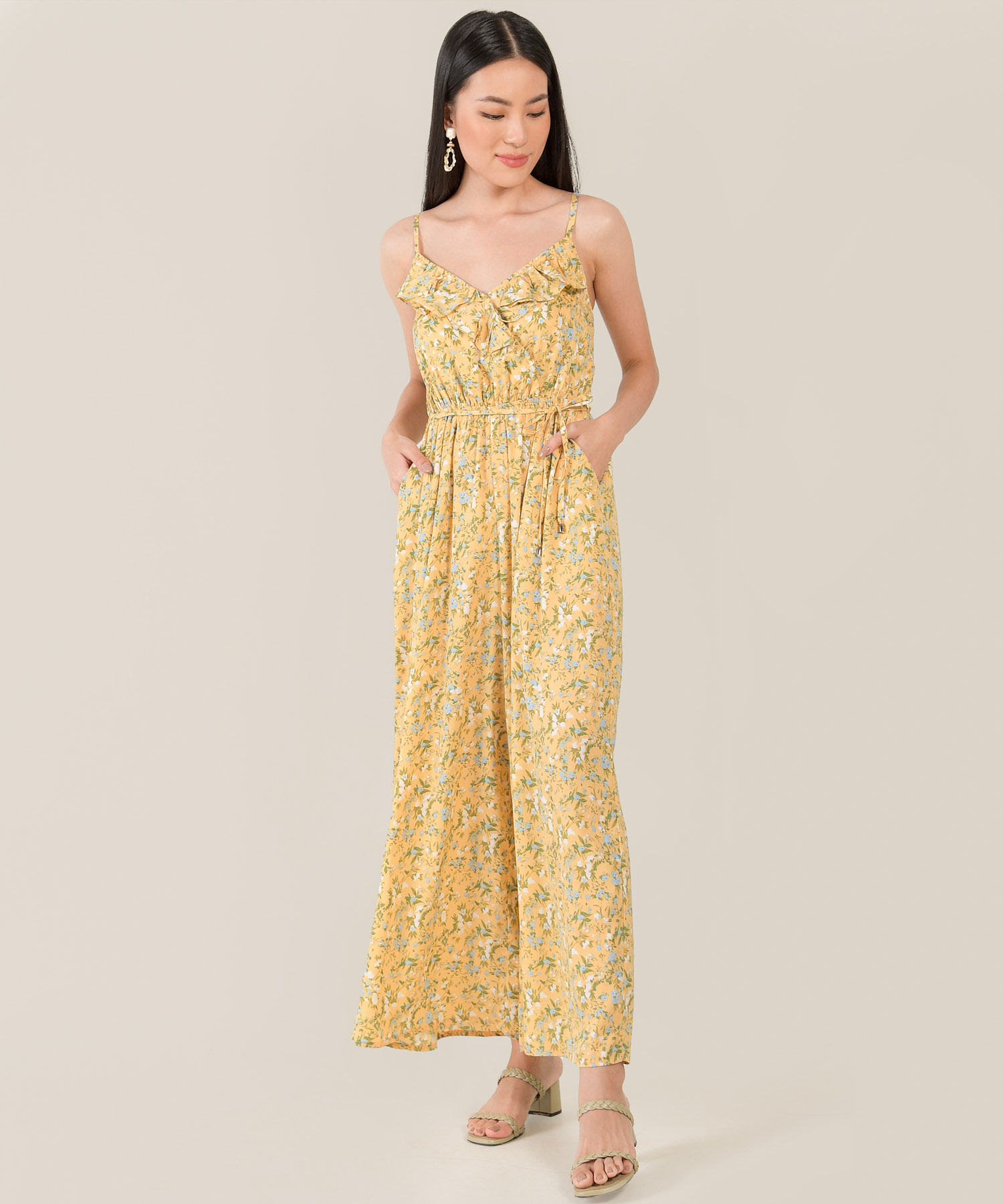 model in resa abstract floral ruffle jumpsuit in daffodil colour hands in pocket