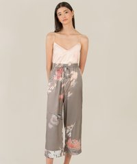 model posing in satin pink camisole and akin olive grey floral satin pants